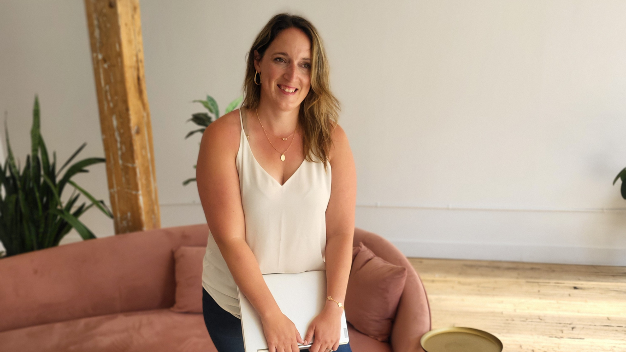 Julie from P&W Designs smiling and staring slightly off to the side with laptop in hand