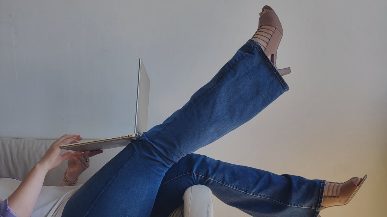 Julie balancing a computer on her legs writing about website ADA compliance