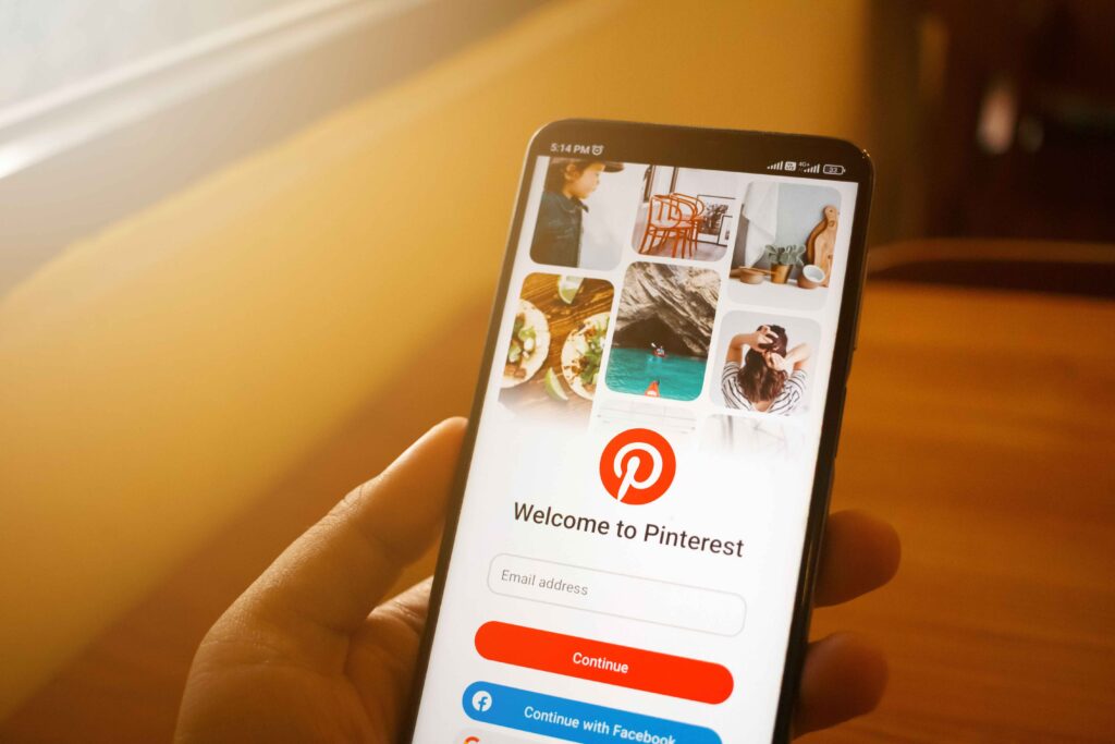 Pinterest login screen on a phone held in one hand